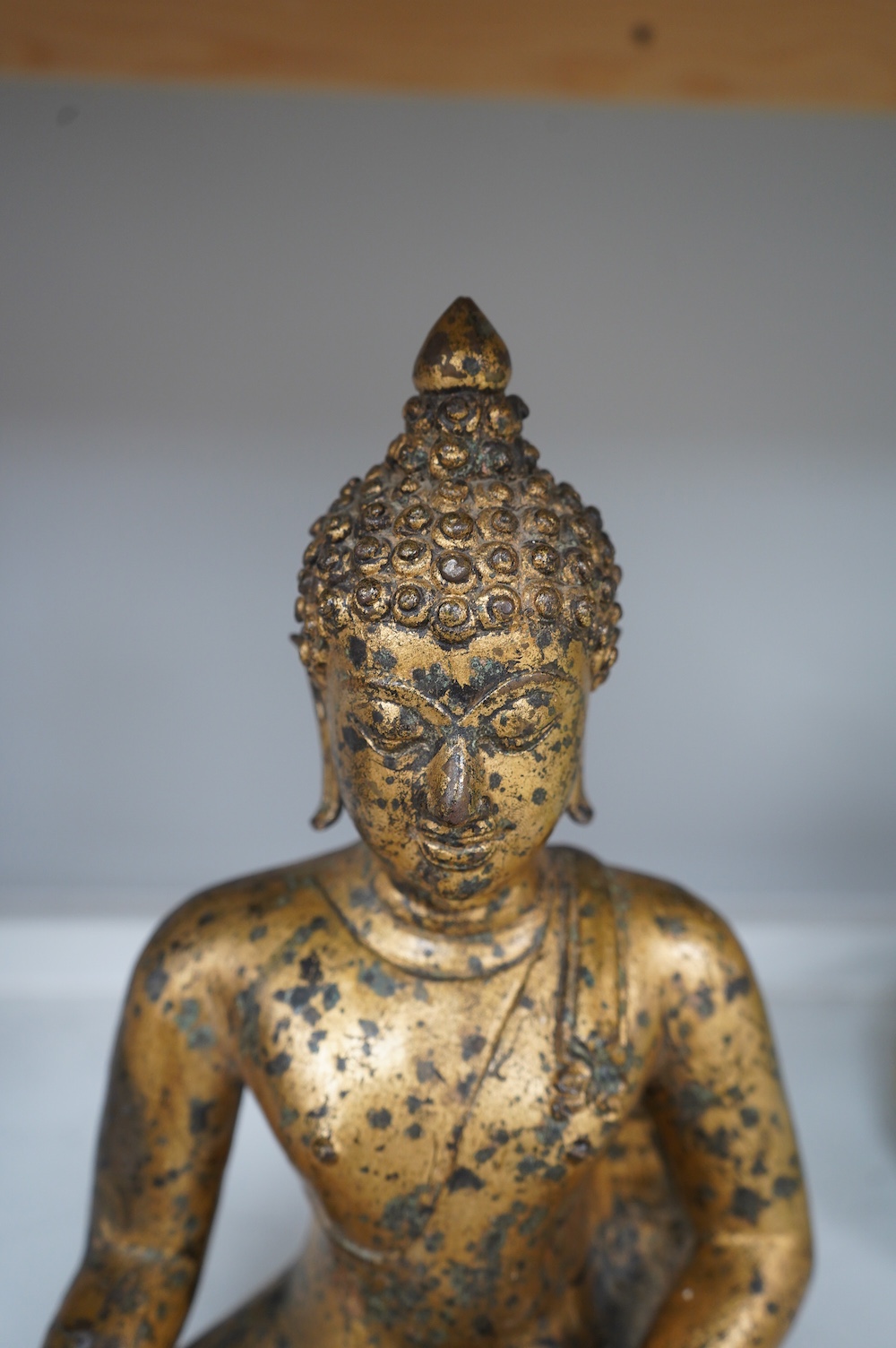 A Chinese gilt bronze figure of seated Buddha, 33cm high. Condition - fair, some holes